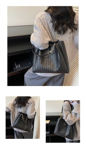 Detail of black woven leather tote bag featuring gold chain strap and texture
