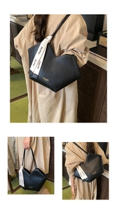 Detail of vintage tote bag featuring black herringbone embossing and fashion metal plaque