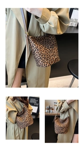 Detail view of leopard print suede bucket bag with adjustable brown leather strap