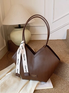 Brown minimalist tote bag with chevron pattern and silk scarf on a warm cozy background