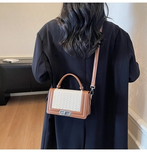 Détail de la texture tressée beige et cuir marron d'un petit sac carré porté en bandoulière