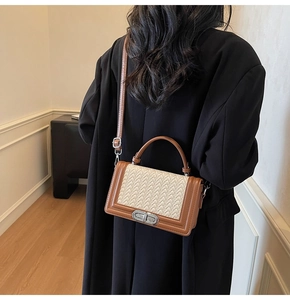 Détail d'un sac bandoulière tissé vintage avec bordure en cuir marron et fermoir rotatif