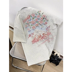 Detail of grey cotton T-shirt featuring a scenic mountain landscape and pink floral print