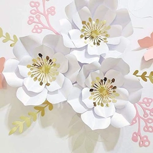Detail of 3D white paper flowers with gold centers and pink branches for party decor