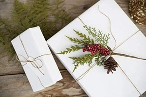 White kraft paper gift wrapping with rustic twine and decorative pine cone accents