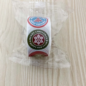 Macro detail of Merry Christmas self-adhesive labels roll for gift packaging decoration