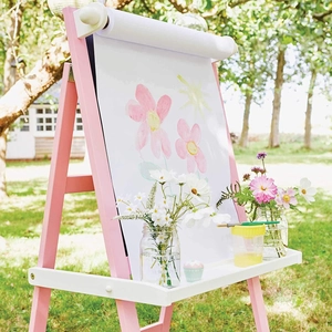 Detail of wooden kids easel featuring integrated white paper roll and art tray