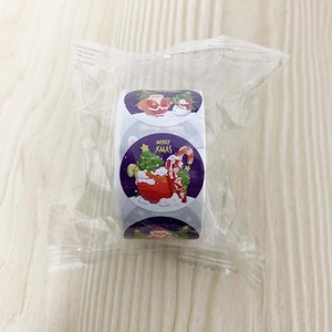 Detail of purple Merry Xmas roll stickers with Santa and snowman on wood background
