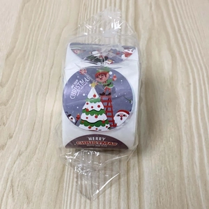 Détail macro du rouleau d'autocollants de Noël avec motifs festifs sur bois clair