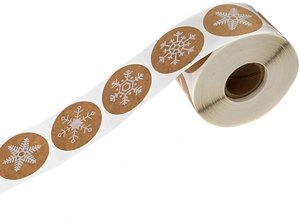 Vue macro des autocollants en rouleau de papier kraft avec motif flocon blanc pour cadeaux