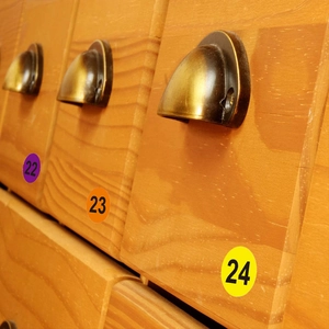 Adesivi colorati numerati da 1 pollice su cassetti in legno per organizzazione