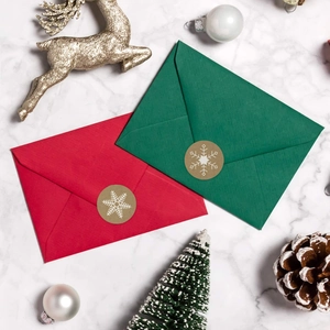 Gros plan d'enveloppes de fête rouges et vertes avec sceaux flocon pour cadeaux de Noël