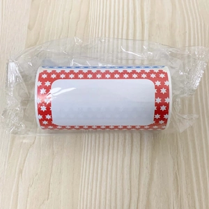 Detail of roll of self-adhesive cartoon name tags with US flag star pattern on wood background
