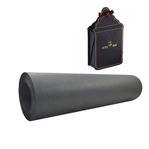 Matte black kraft paper roll with a sample birthday gift bag featuring a brown bow