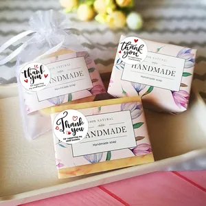 Detail of natural handmade soap set with floral paper wrap and white organza gift bag