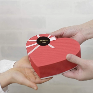 Red heart gift box with white ribbon and gold foil Thank You sticker for celebrations