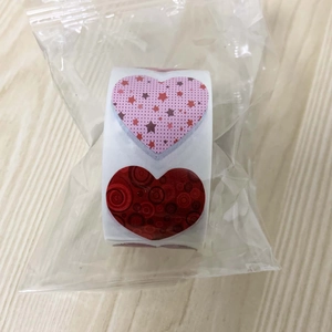 Detail of 1-inch heart-shaped roll stickers with pink stars and red swirl patterns