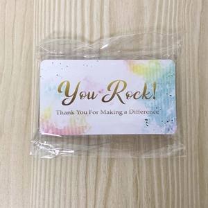Detail of colorful watercolor incentive cards with 'You Rock' text on wood background