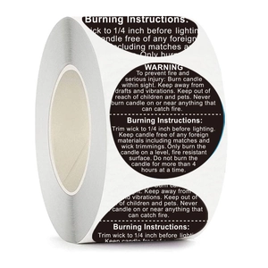 Roll of black round candle warning labels with white text and burning instructions