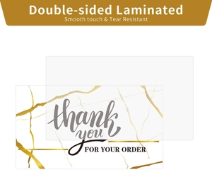 Macro shot of double-sided laminated thank you cards with gold marble texture