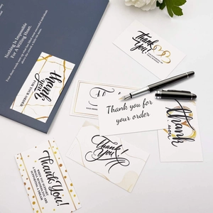 Flat lay of marble style thank you for your order cards and elegant office stationery