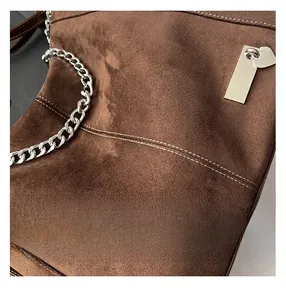 Detailansicht der dunkelbraunen Matten Ledertasche mit weißen Nähten und Silberkette