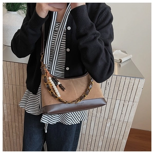 Détail du sac seau en daim avec chaîne en métal épaisse et pendentif en perles colorées