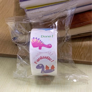 Close-up of colorful round dinosaur reward stickers with motivational words for children