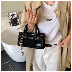 Detail view of black vintage baguette bag with beaded tassel and gold hardware