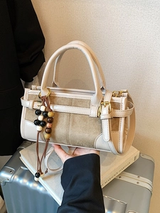 Chic beige crossbody baguette bag with wooden bead charm and suede leather texture