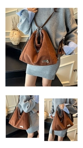 Detailansicht der braunen matten Ledertasche mit Silberkette und Herz-Anhänger-Zubehör