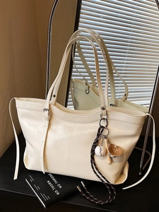 Vintage beige oversized tote bag with baseball charm and textured finish for autumn 2025