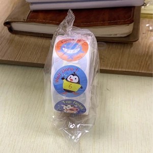 Macro detail of colorful animal reward stickers with encouraging English phrases on roll