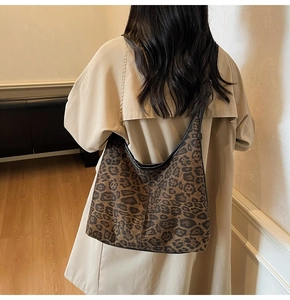 Detailed view of the large leopard print tote bag with black leather shoulder strap and trim