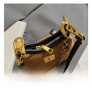 Detail of vintage suede shoulder bag with diamond quilting and gold-tone chain hardware