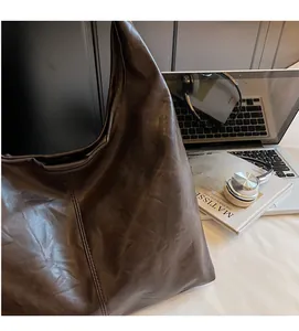 Detail of soft dark brown leather tote bag with vertical stitching for daily work