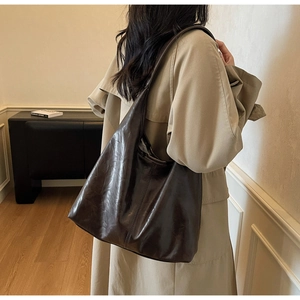 Close-up of vintage dark brown tote bag with high-shine faux leather oil-wax finish