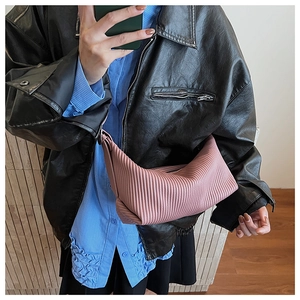 Detailed view of pink pleated crescent handbag with zipper and soft faux leather texture