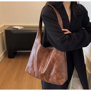 Dettaglio della grande borsa tote marrone vintage con texture in pelle oliata e tracolla