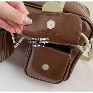 Detail of durable patch pocket and silver magnetic closure on brown faux leather bag