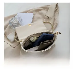 Detailed interior view of beige quilted bag showing storage for phone and wallet