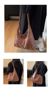 Detail of vintage brown tote bag showing glossy oil-wax leather texture and wide strap