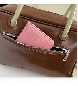 Detail of oil wax leather shoulder bag with side zipper pocket showing card holder storage