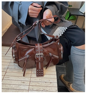 Detail of dark brown vintage motorcycle bag with silver zippers and buckle straps