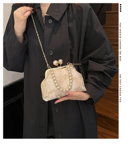 Détail du sac vintage en brocart crème avec broderie florale et fermoir perle chic