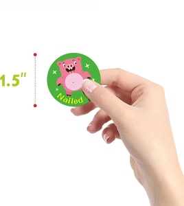 Detail view of a 1.5-inch round animal sticker showing a pink pig and Nailed text