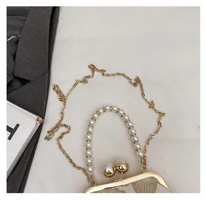 Detail of floral jacquard bag with pearl clasp and golden chain strap