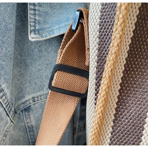 Detail of adjustable canvas strap and durable buckles on striped tote bag for women