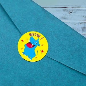 Detail of round hippo sticker with WOW text used as a seal on a blue textured envelope