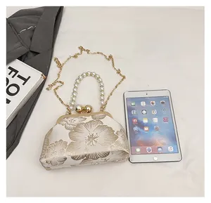Détail du sac à main vintage brodé beige avec poignée en perles et fermoir métallique